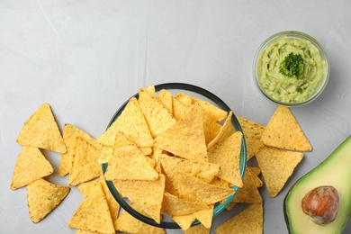 Flat lay composition with tasty Mexican nachos chips on grey table, space for text