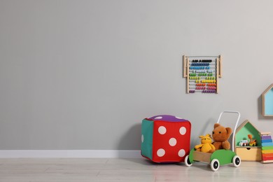 Photo of Beautiful children's room with grey wall and toys, space for text. Interior design