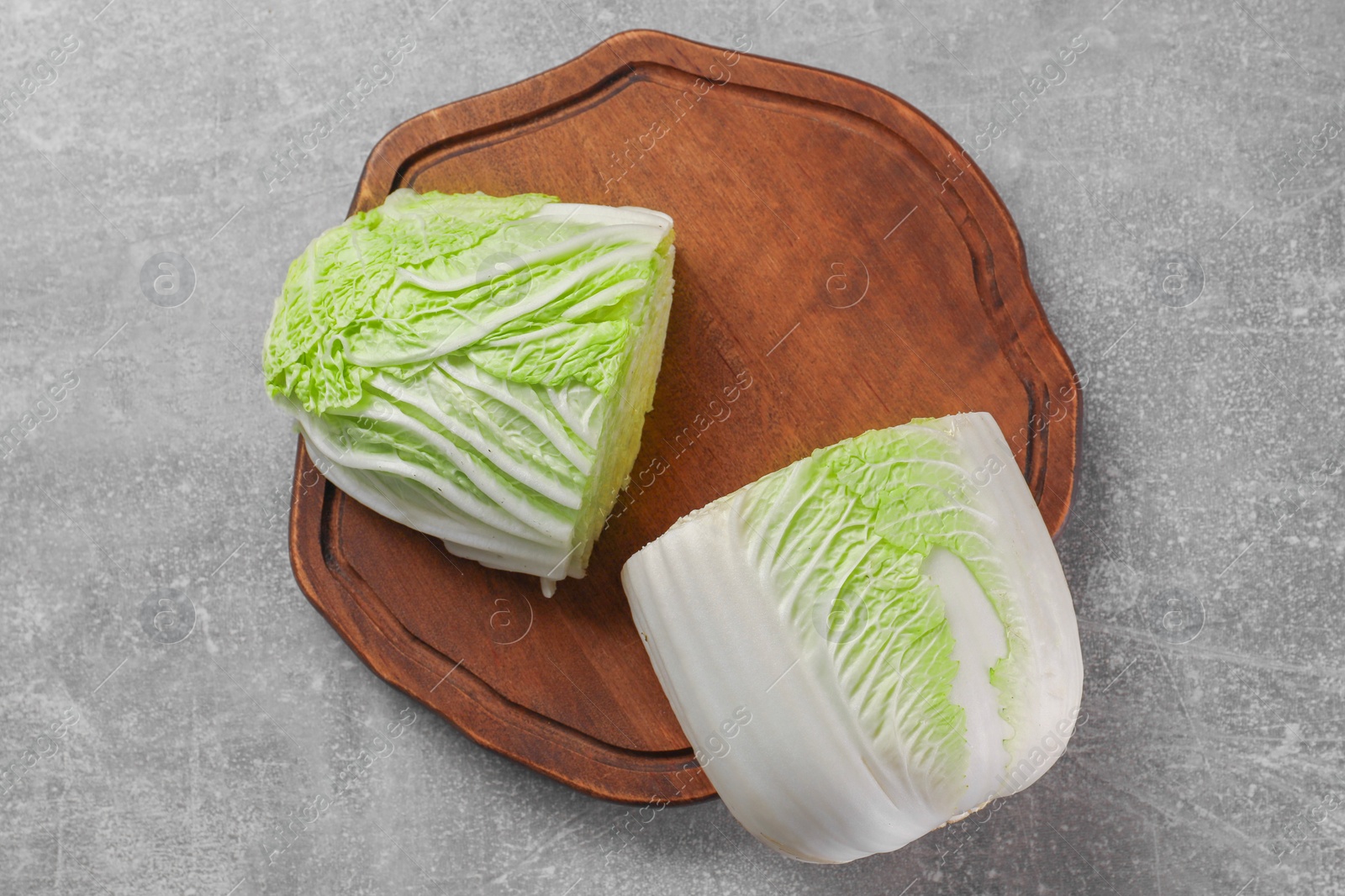 Photo of Halves of fresh Chinese cabbage on light grey table, top view