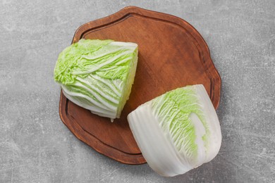 Photo of Halves of fresh Chinese cabbage on light grey table, top view