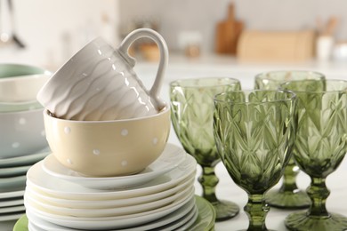 Many different clean dishware, glasses and cup on table indoors, closeup