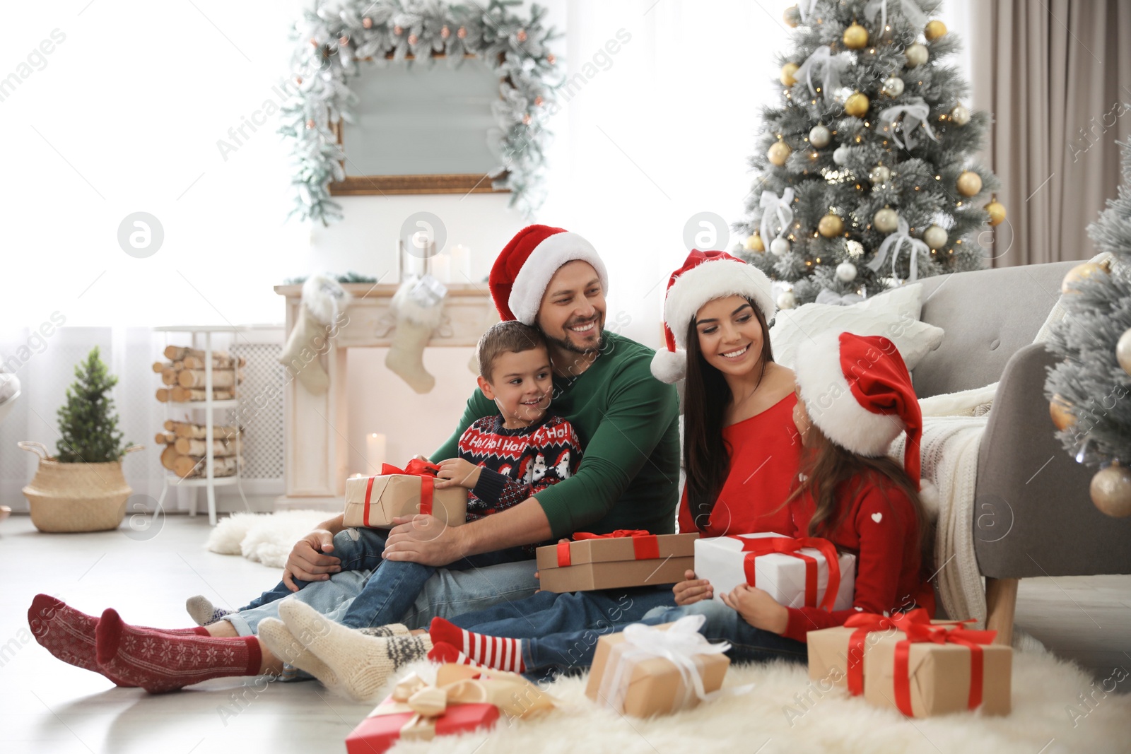 Photo of Happy family with Christmas gifts on floor at home
