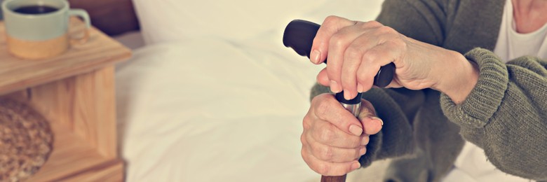 Image of Elderly woman with walking cane indoors, closeup. Banner design