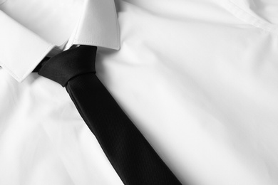 Black male necktie on white shirt, closeup. Space for text