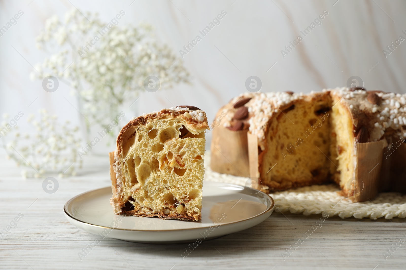 Photo of Delicious Italian Easter dove cake (traditional Colomba di Pasqua) on white wooden table, space for text