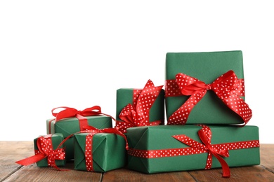 Many Christmas gifts on wooden table against white background