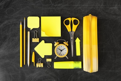 Photo of Different stationery on blackboard, flat lay. Back to school