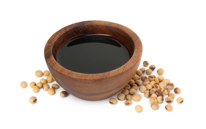 Photo of Tasty soy sauce in bowl and soybeans isolated on white