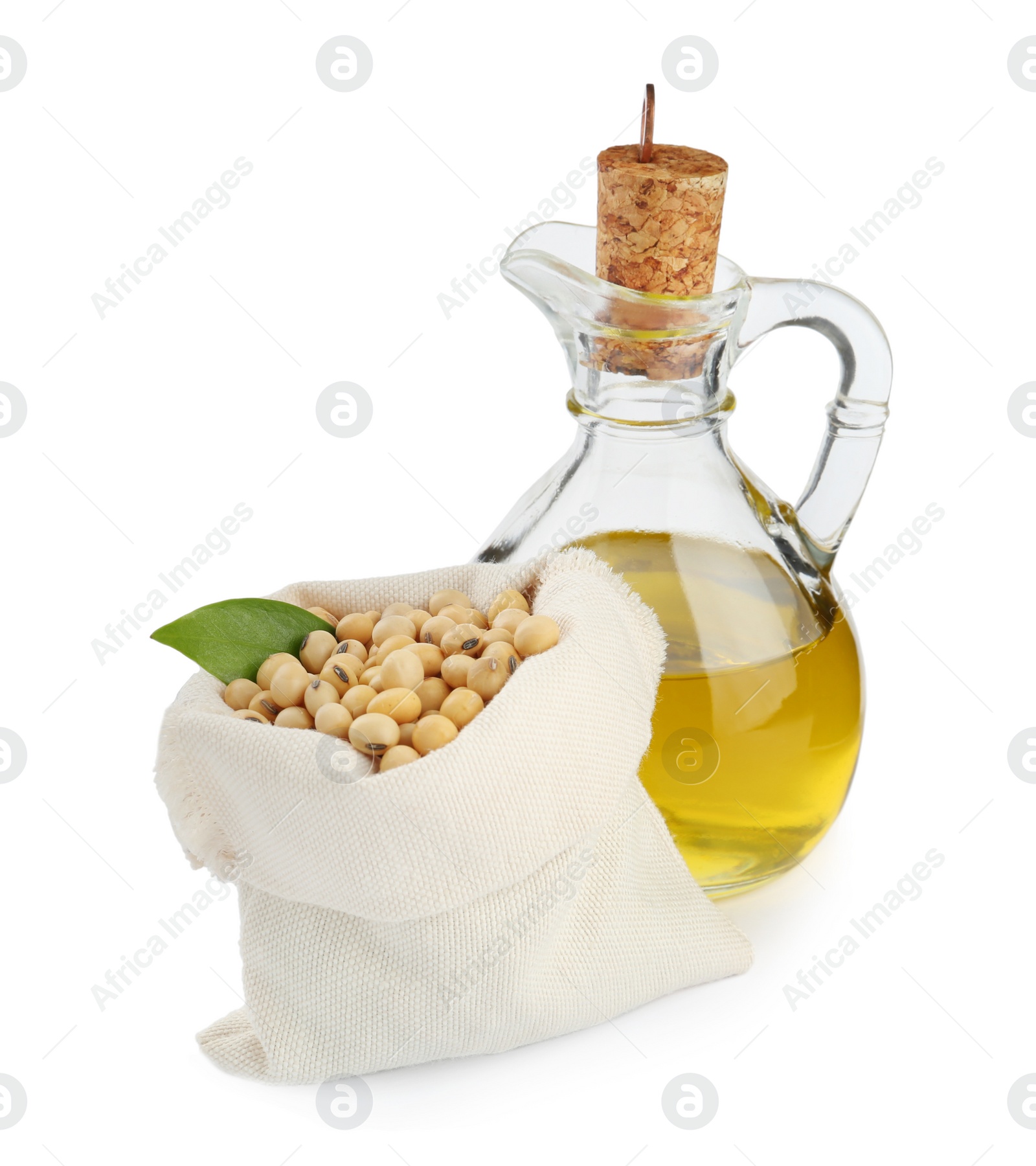 Photo of Glass jug of oil and soybeans on white background