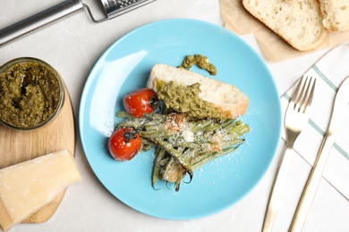 Photo of Delicious baked green beans on grey table, flat lay