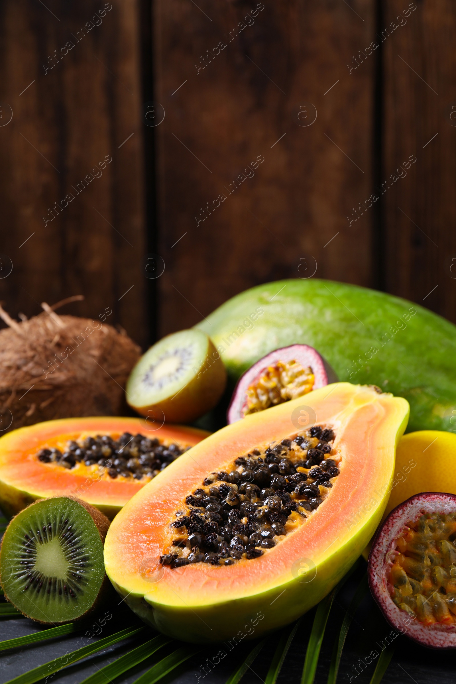 Photo of Fresh ripe papaya and other fruits on table