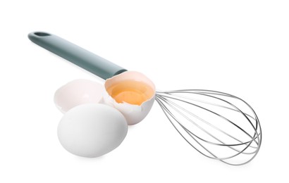 Photo of Whisk, whole and broken eggs isolated on white