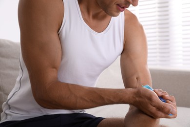 Photo of Athletic man injecting himself indoors, closeup. Doping concept