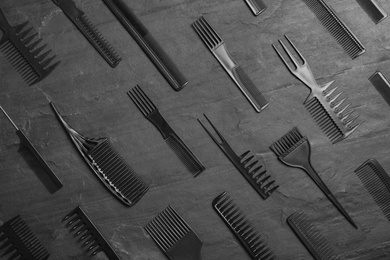 Photo of Set of combs on black slate background, flat lay