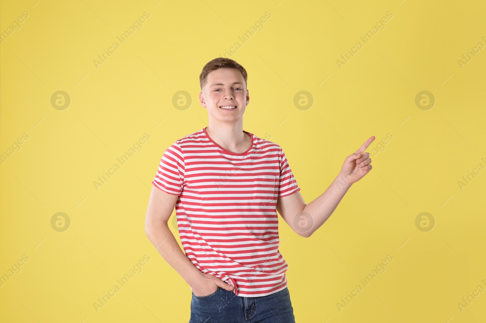 Photo of Portrait of teenage boy on yellow background