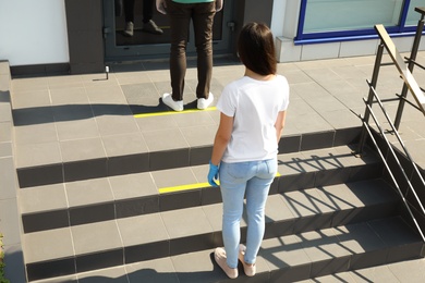 People keeping social distance in line on stairs outdoors. Coronavirus pandemic