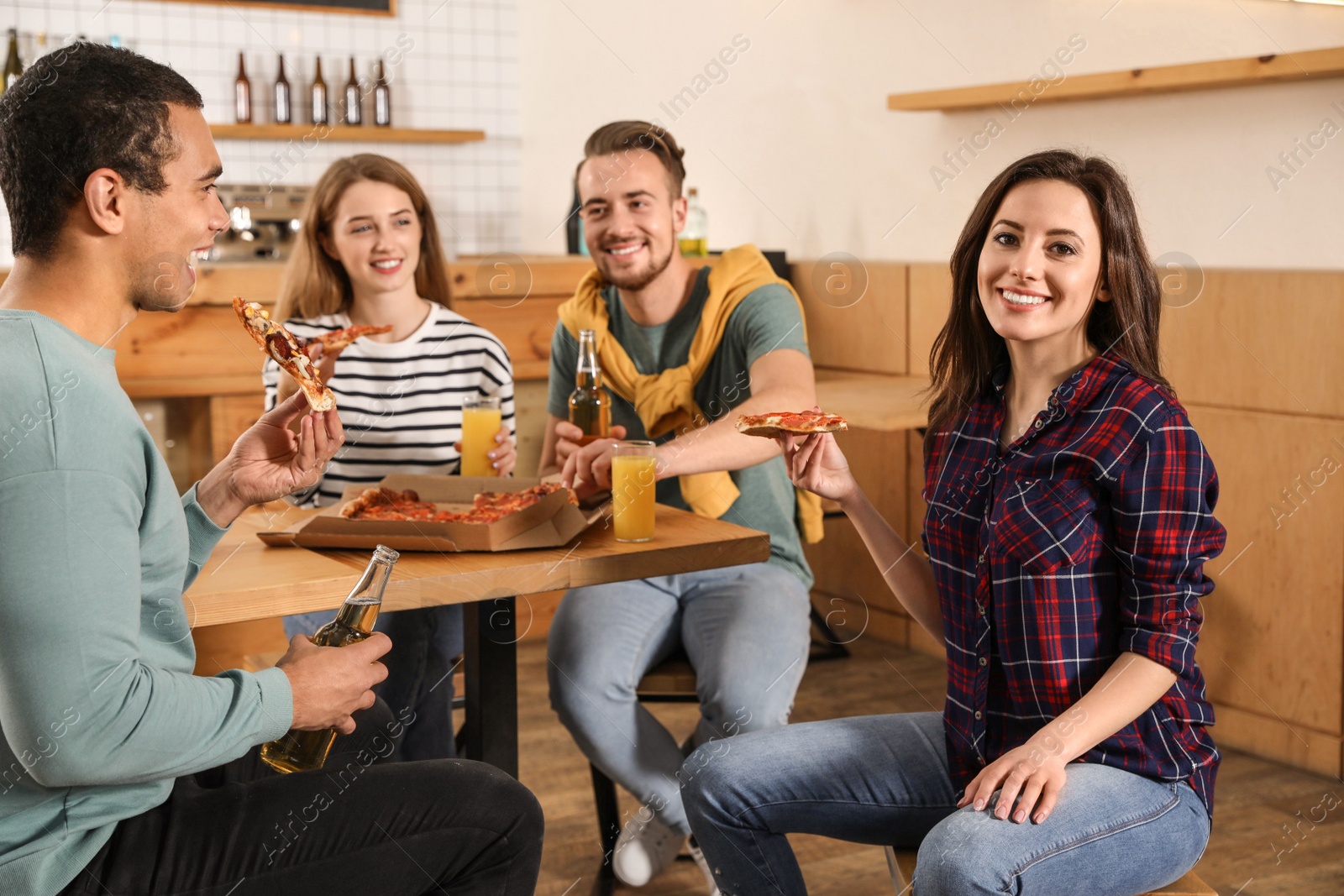 Photo of Group of friends having fun party with delicious pizza in cafe