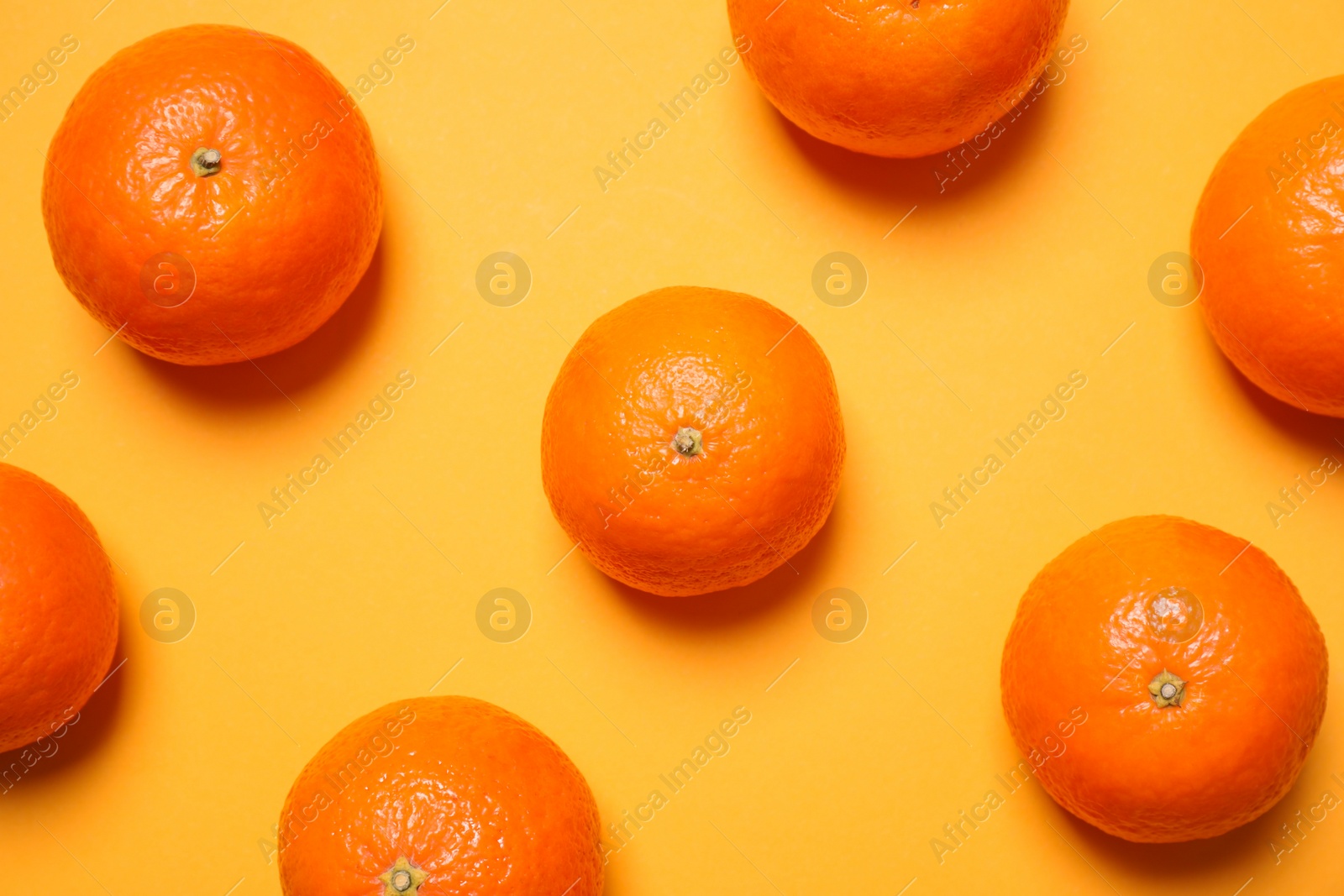 Photo of Fresh ripe tangerines on yellow background, flat lay