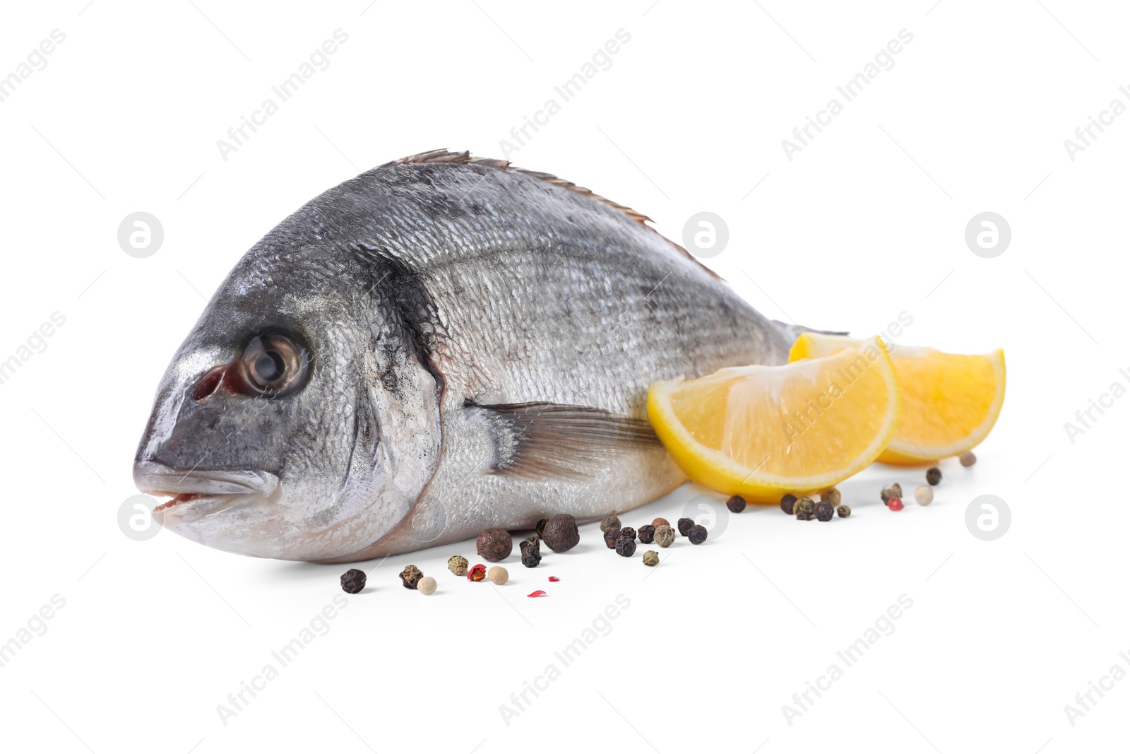 Photo of Raw dorado fish, lemon wedges and peppercorns isolated on white