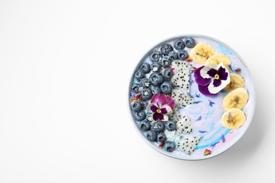 Delicious smoothie bowl with fresh fruits, blueberries and flowers on white background, top view. Space for text