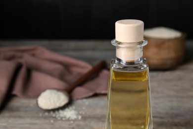 Bottle of organic sesame oil on wooden table, closeup. Space for text