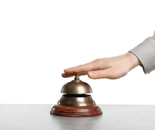 Photo of Woman ringing hotel service bell at grey stone table