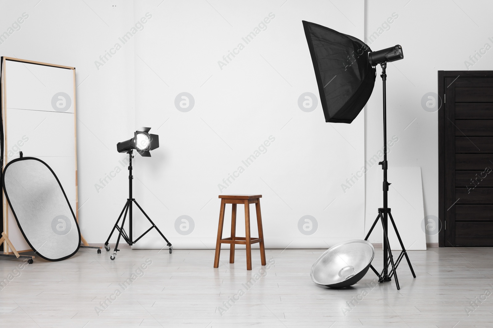 Photo of White photo background, stool and professional lighting equipment in studio