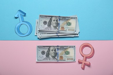 Gender pay gap. Male and female symbols with dollar banknotes on color background, flat lay