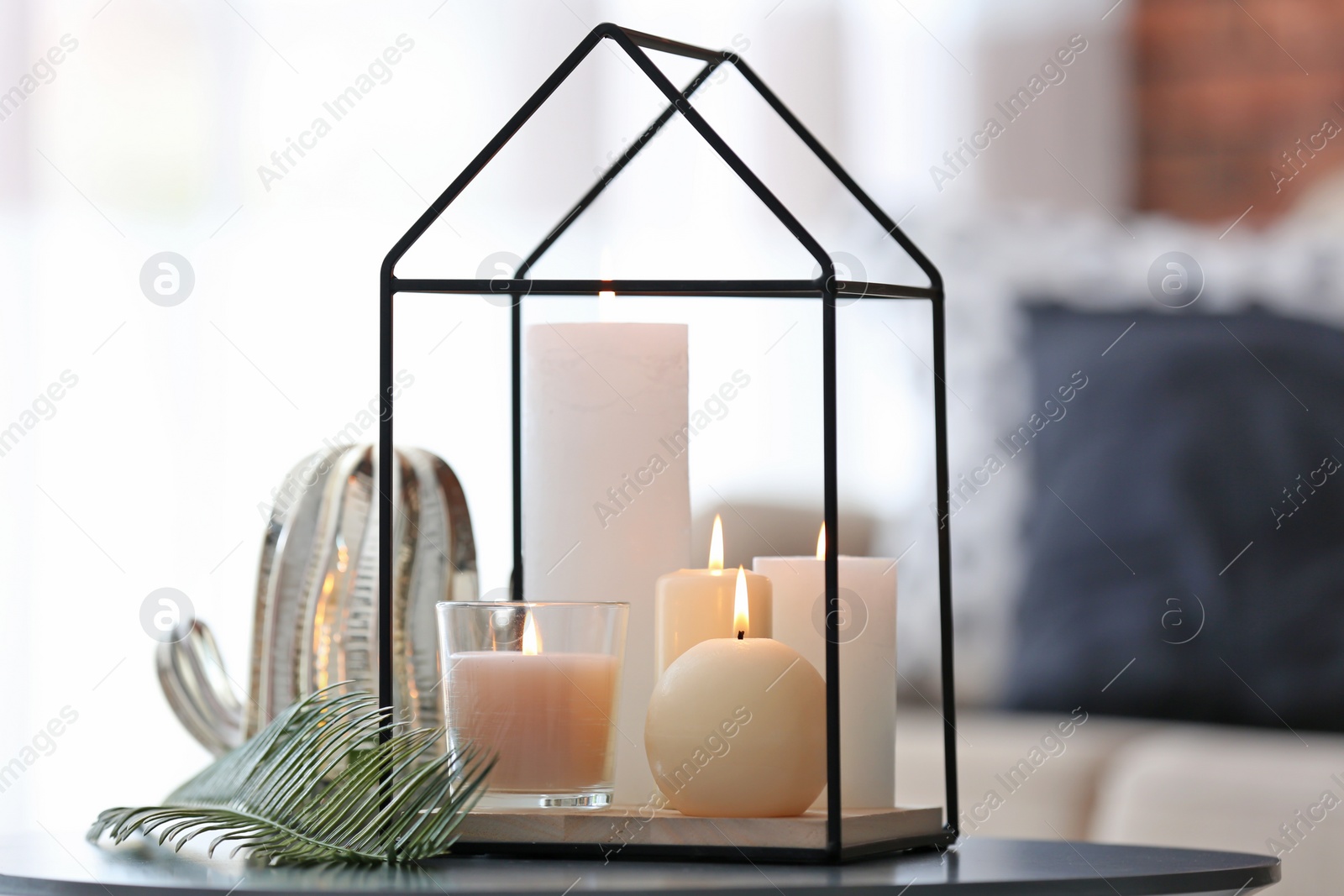 Photo of Burning candles on table against blurred background