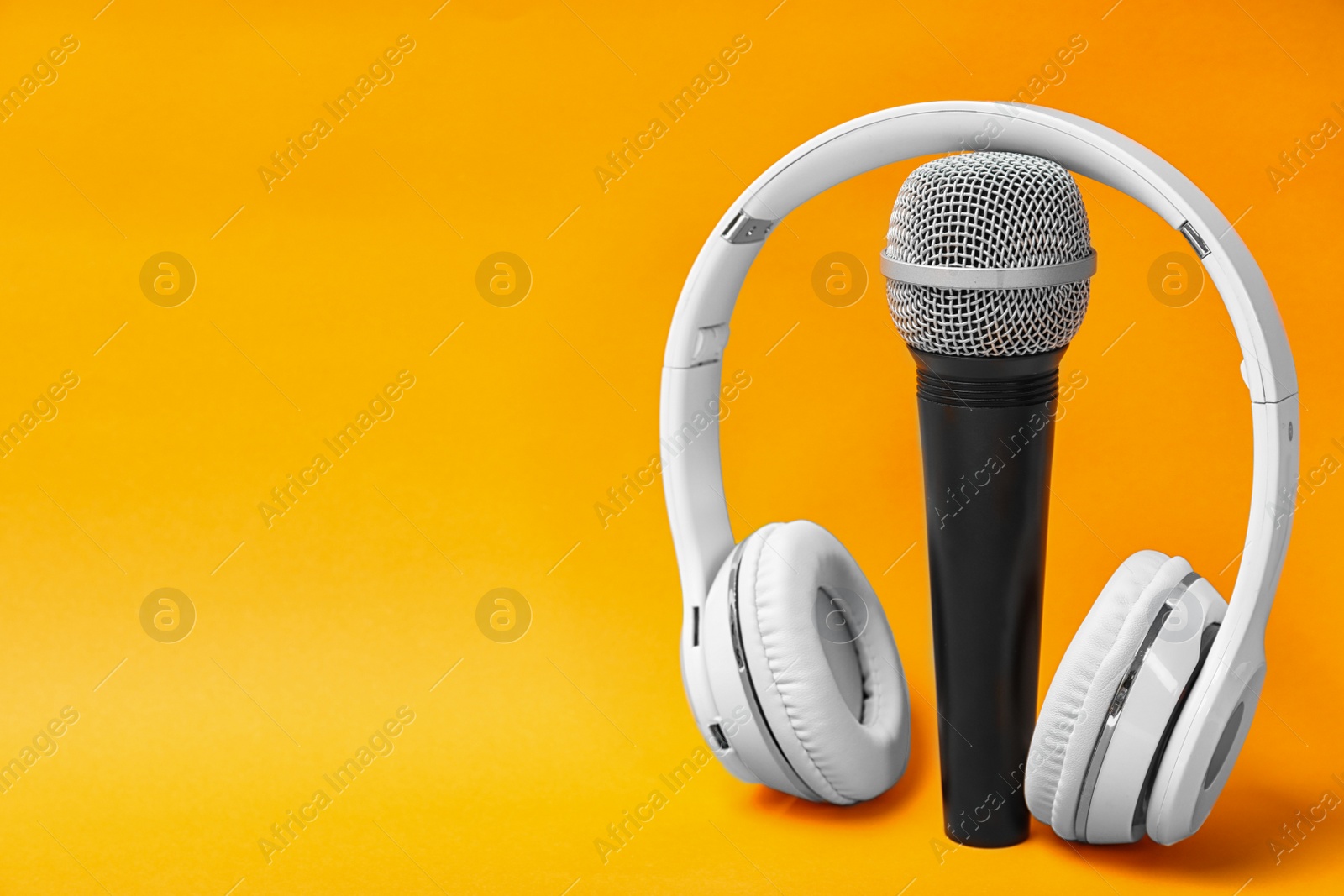 Photo of Microphone, headphones and space for text on color background