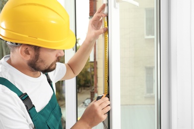 Construction worker installing new window in house