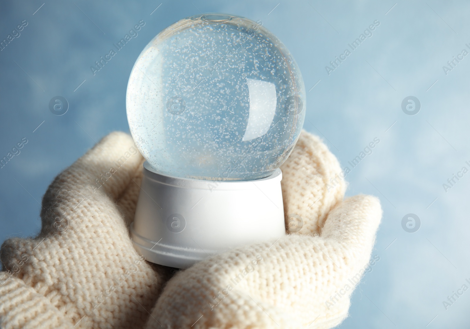 Photo of Woman holding empty snow globe on color background, closeup