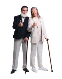 Senior man and woman with walking canes showing thumbs up on white background