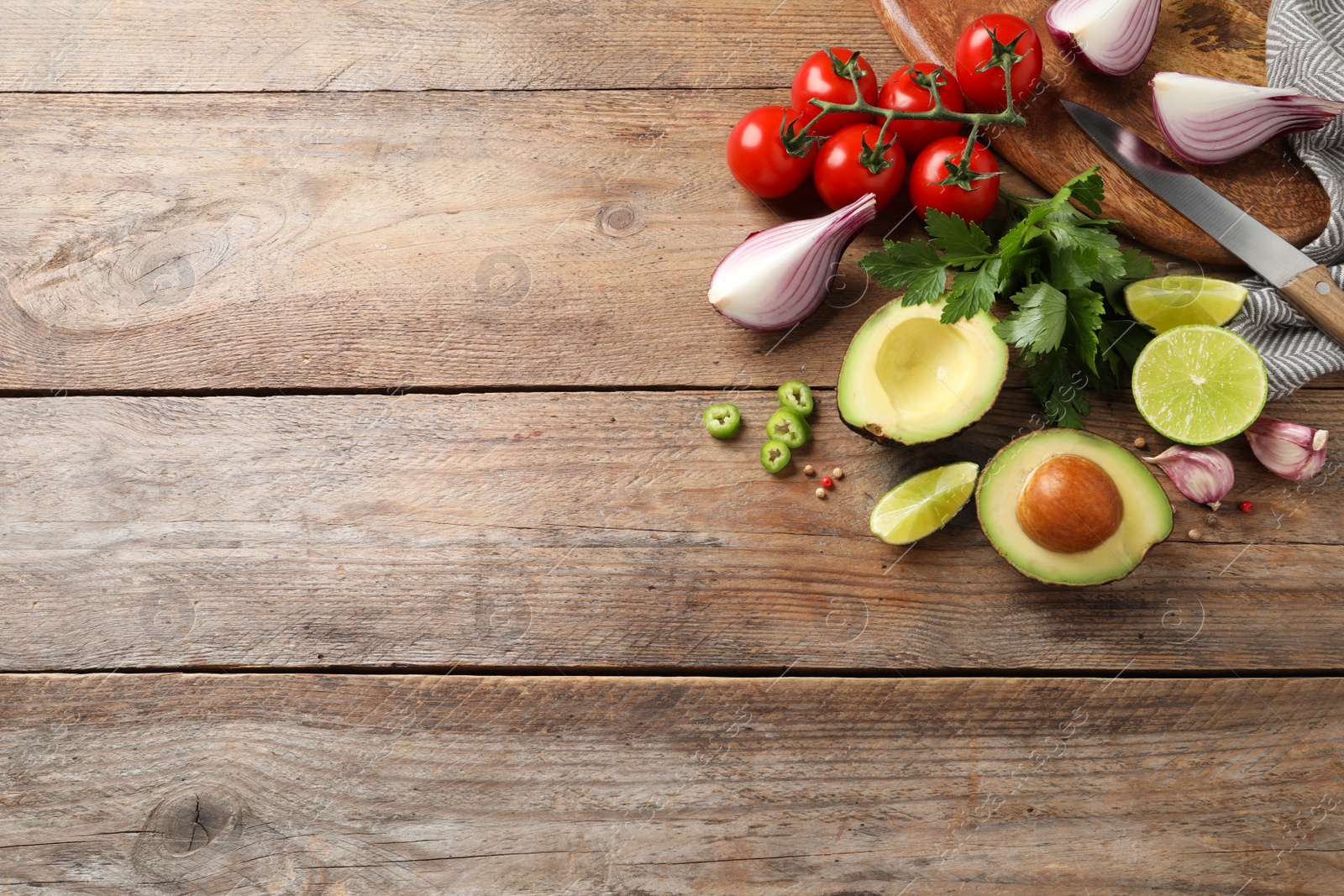 Photo of Fresh guacamole ingredients on wooden table, flat lay. Space for text