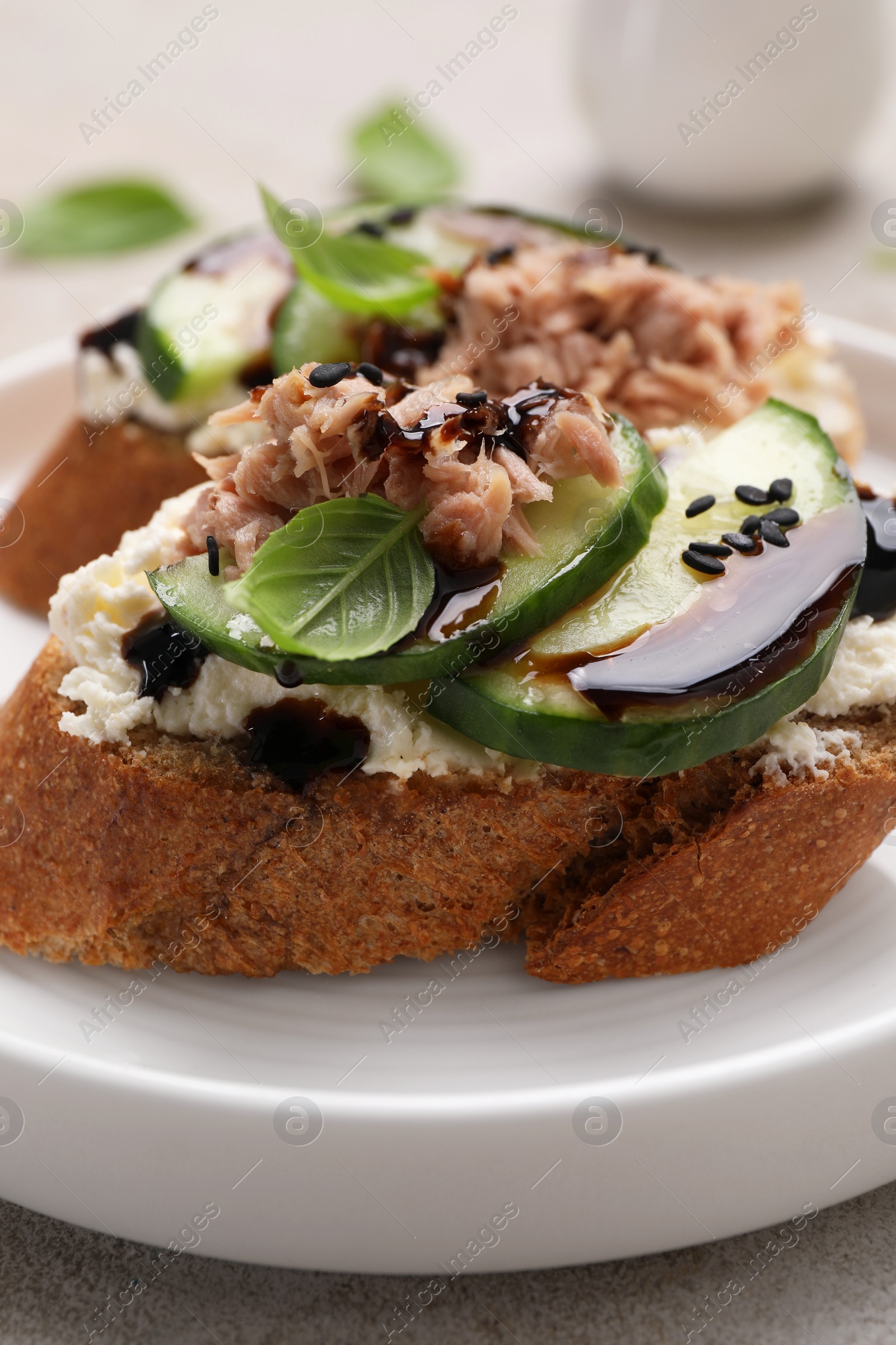 Photo of Delicious bruschettas with balsamic vinegar and toppings on grey table, closeup