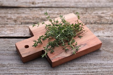 Board with aromatic fresh thyme on wooden table