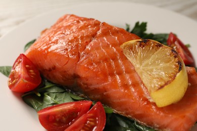 Photo of Tasty grilled salmon with tomatoes, lemon and basil on plate, closeup