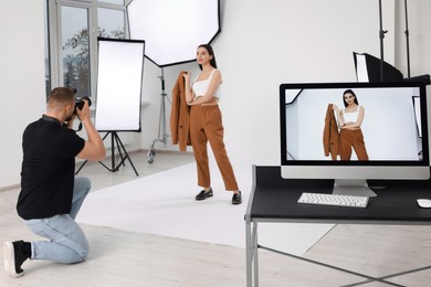 Photo of Professional photographer working with beautiful model in modern photo studio