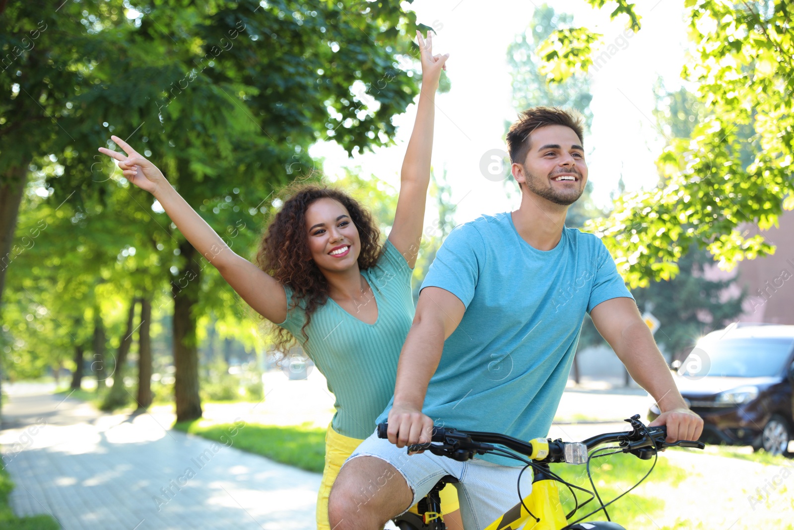 Photo of Happy young couple riding bicycle on city street