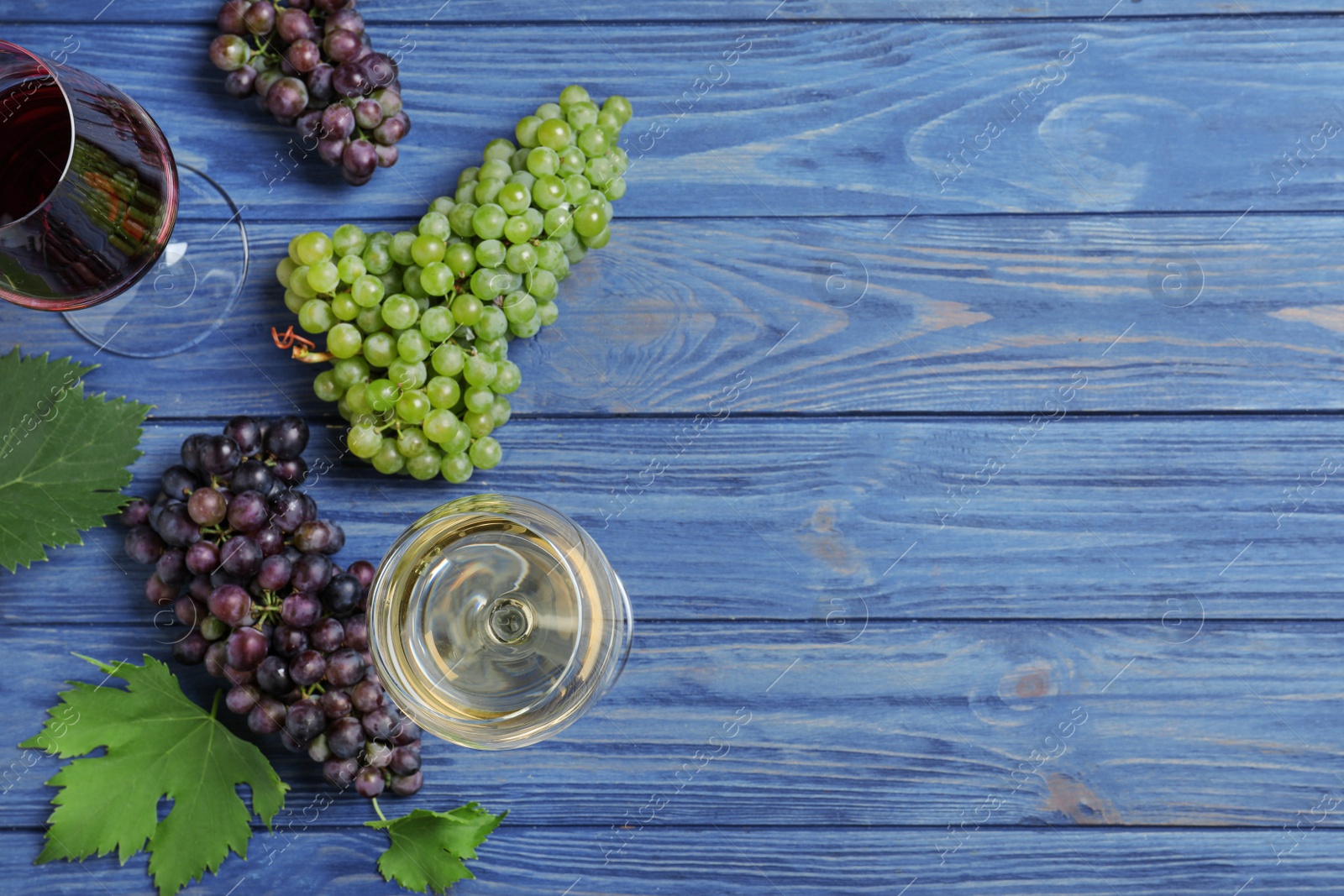 Photo of Flat lay composition with fresh ripe juicy grapes on blue wooden table. Space for text