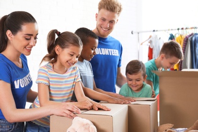 Photo of Volunteers with children sorting donation goods indoors