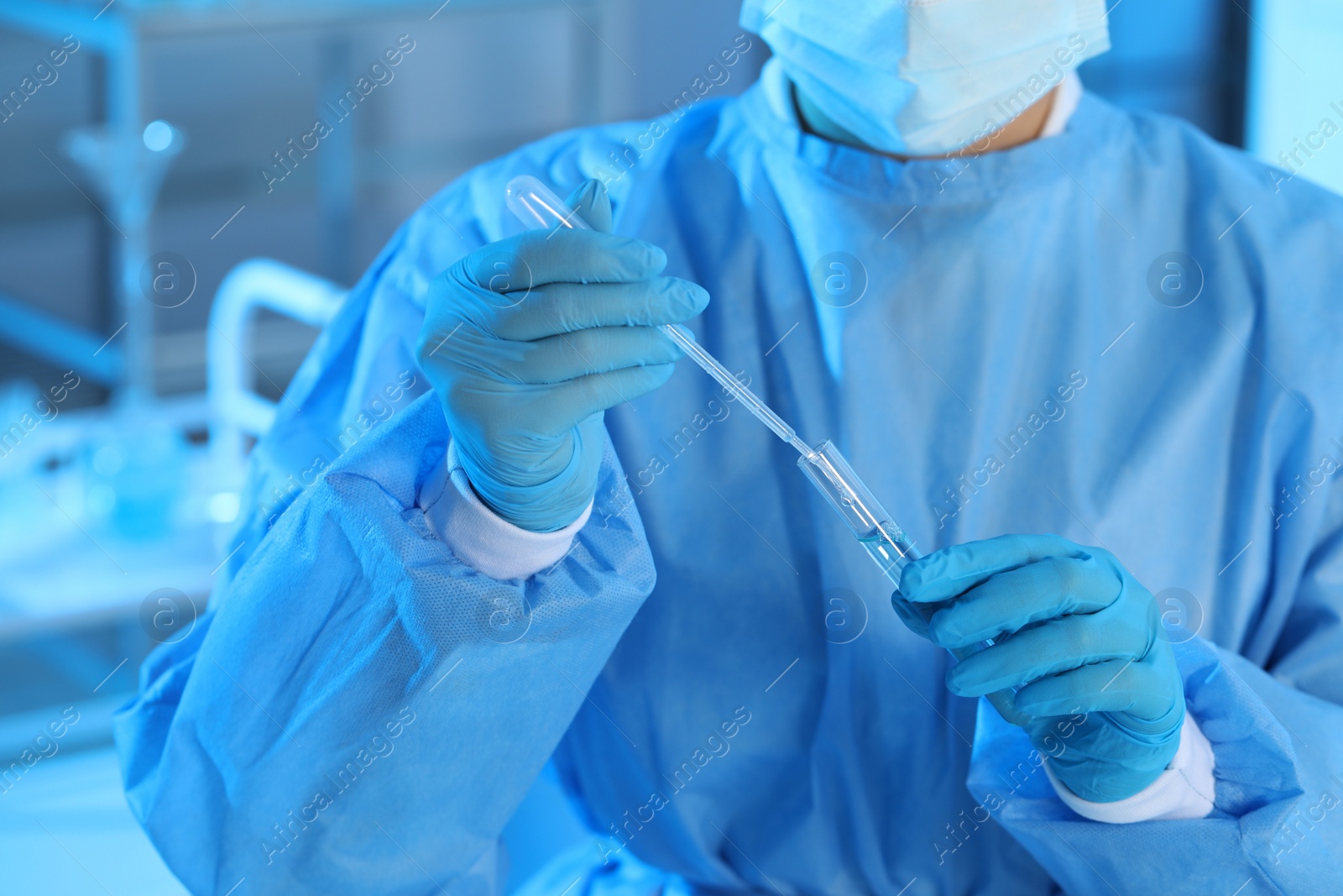 Photo of Scientist dripping sample into test tube in laboratory, closeup. Medical research