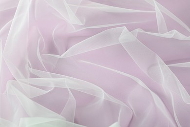 Photo of Beautiful white tulle fabric on lilac background