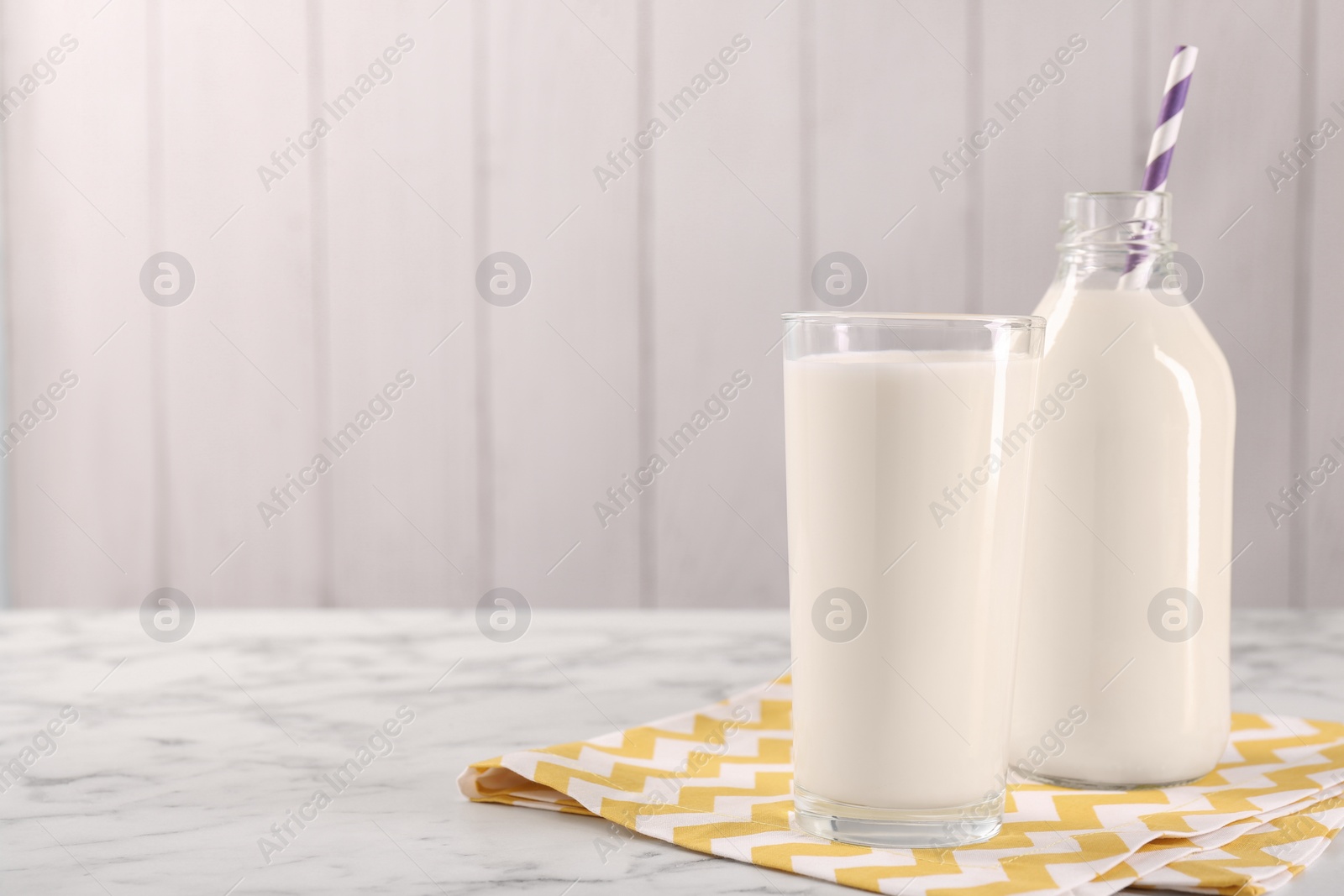 Photo of Glassware with tasty milk on white marble table, space for text