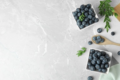 Photo of Flat lay composition with tasty blueberries on grey marble table, space for text