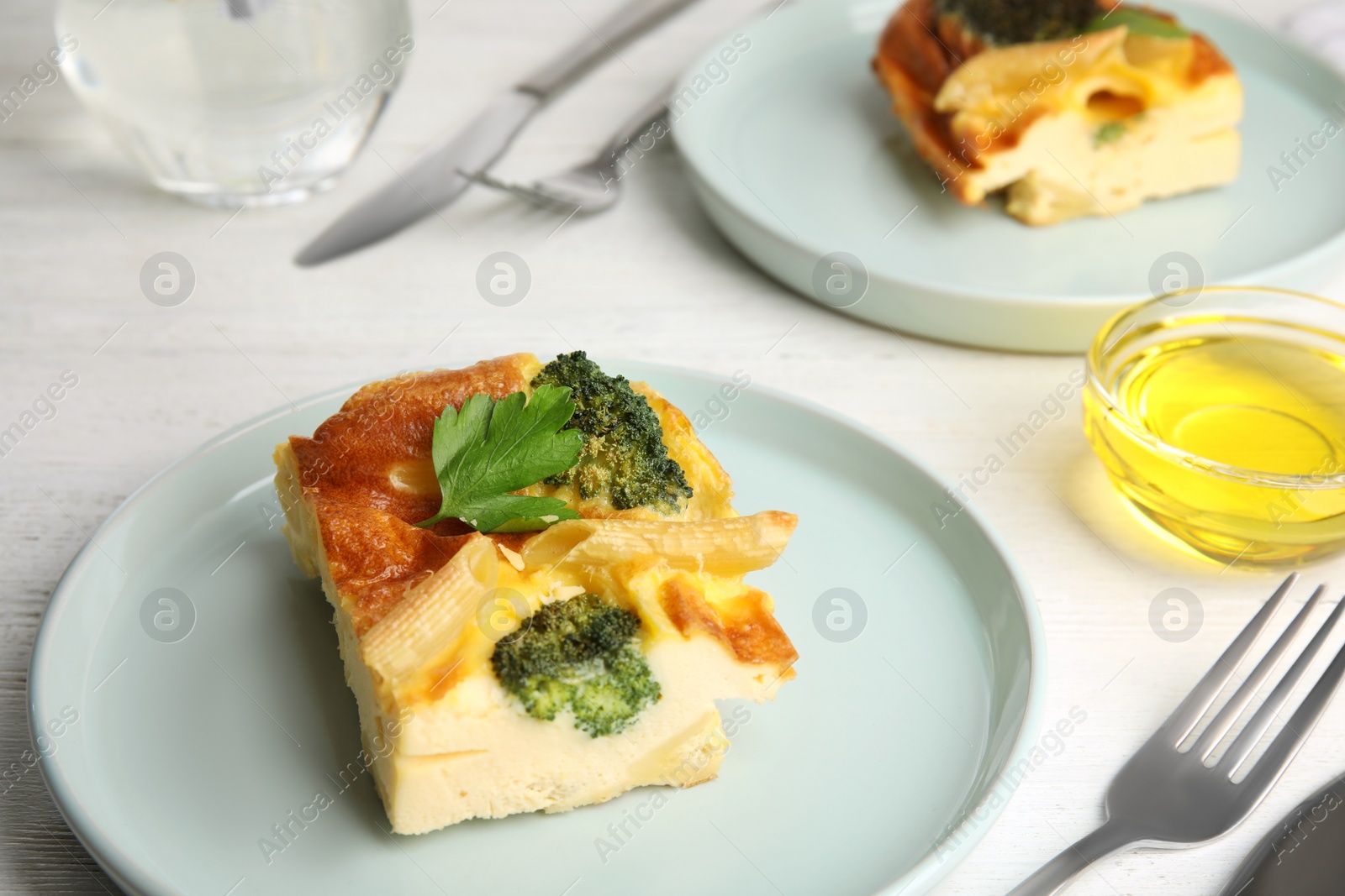 Photo of Tasty broccoli casserole served on white wooden table