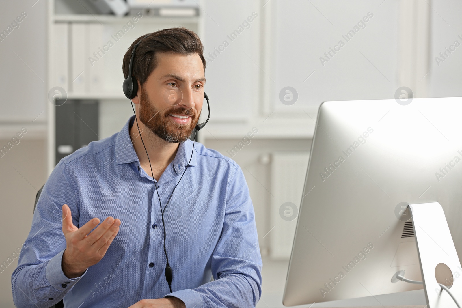 Photo of Hotline operator with headset working in office