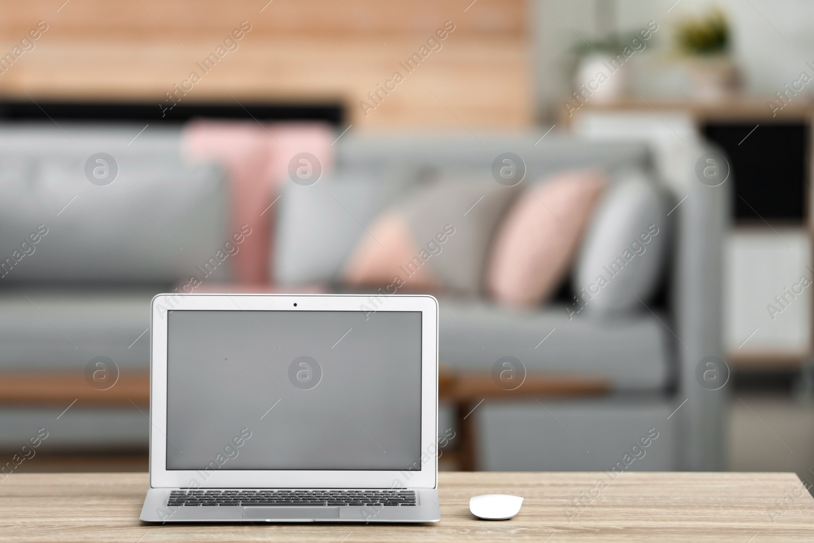 Photo of Laptop with blank screen on table indoors. Space for text