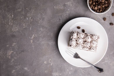 Flat lay composition with tiramisu cake and coffee beans on grey background, space for text