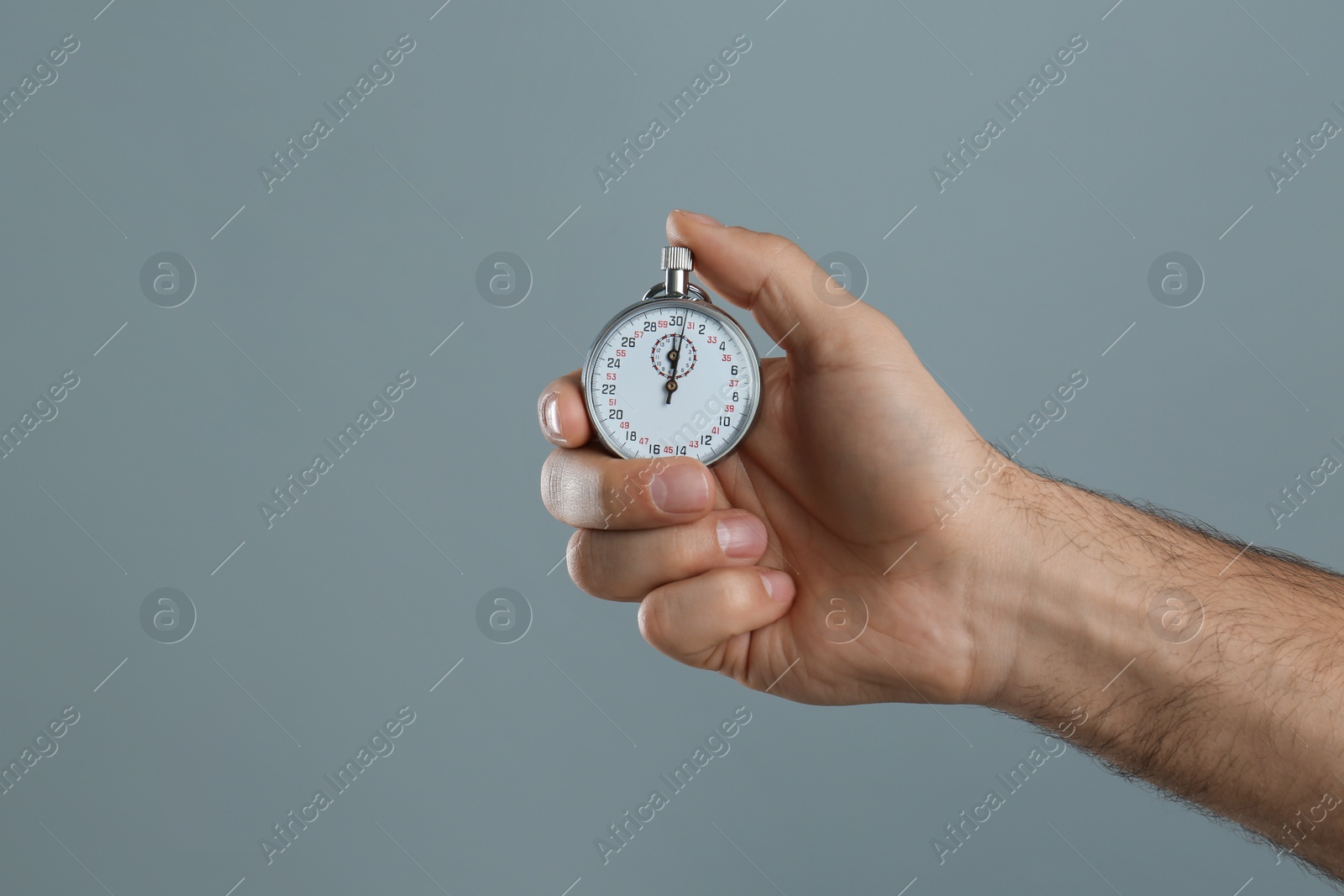 Photo of Man holding vintage timer on grey background, closeup